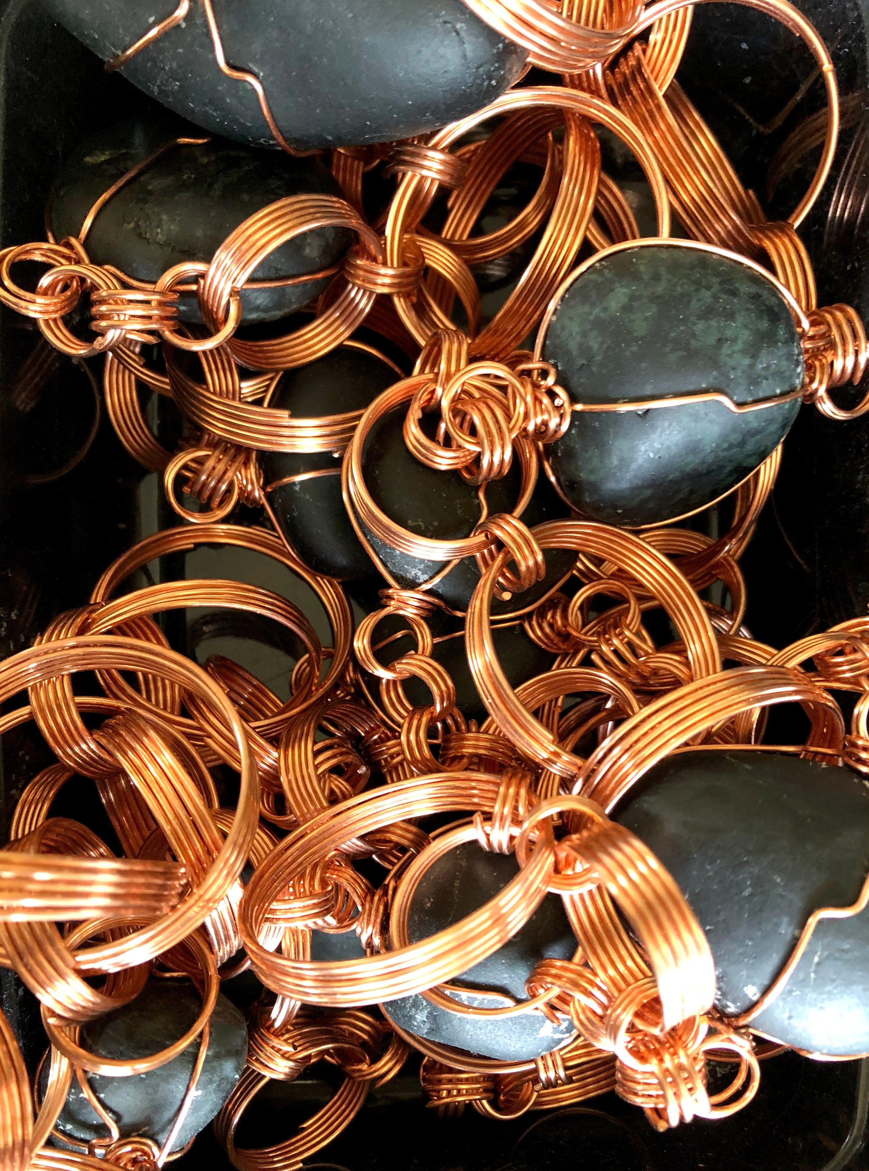Handmade copper chain links and wrapped jade stones in a box