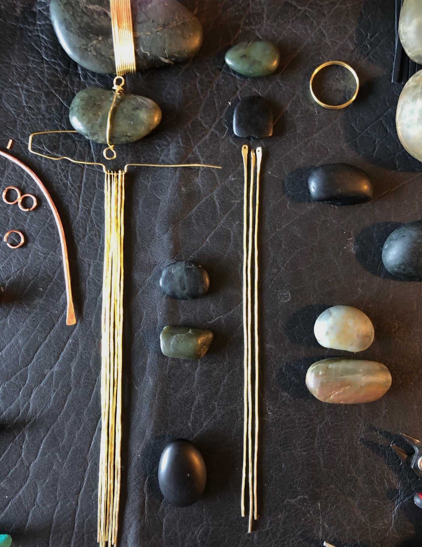 Jade stones and brass sculpture elements on Gretchen’s workbench